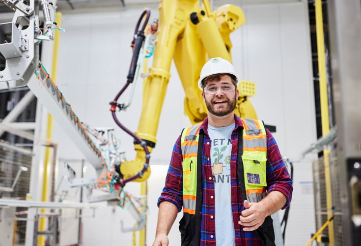 Plenty male technician standing inside of vertical farming system