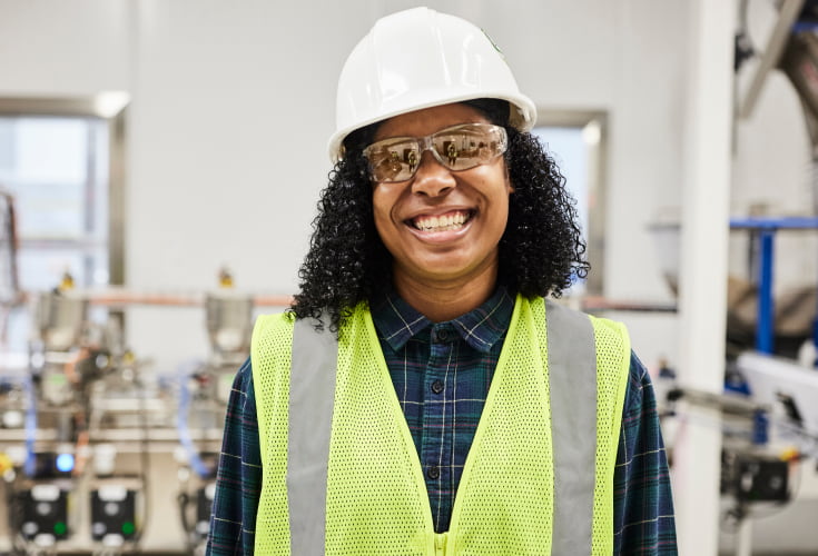 Plenty female technician standing inside of vertical farming system
