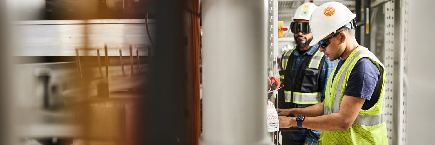 Two Plenty employees are working on Plenty's vertical farm system